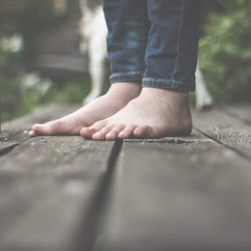 A pair of feet standing on wooden boards.