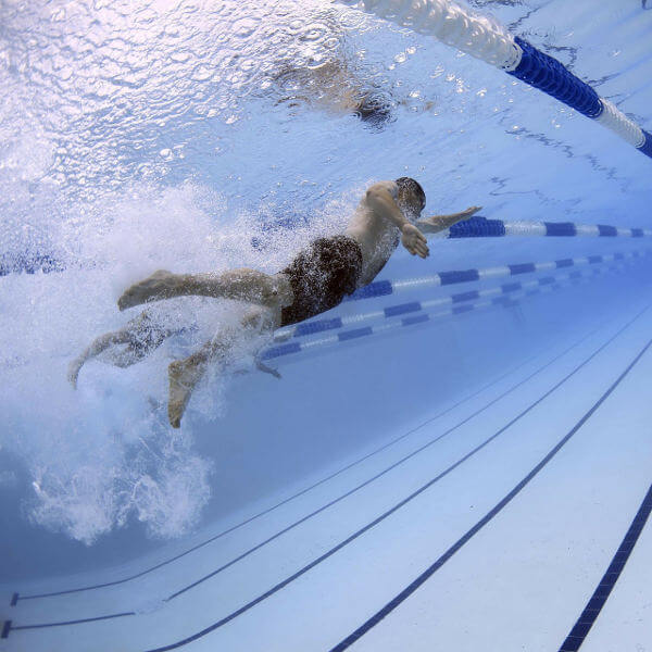 Person swimming in an in-door pool.