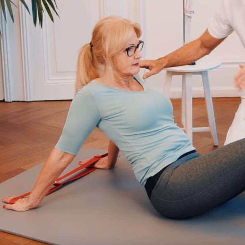 Woman using the exercise loop to do an exercise against shoulder pain.