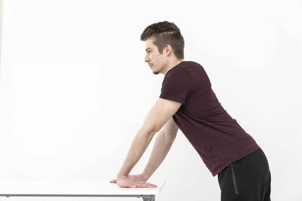 A man is stretching his arms to relieve his RSI syndrome.
