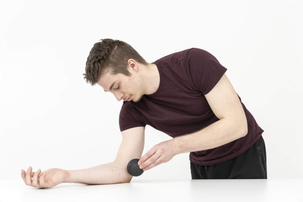 A man is massaging the inside of his elbow.