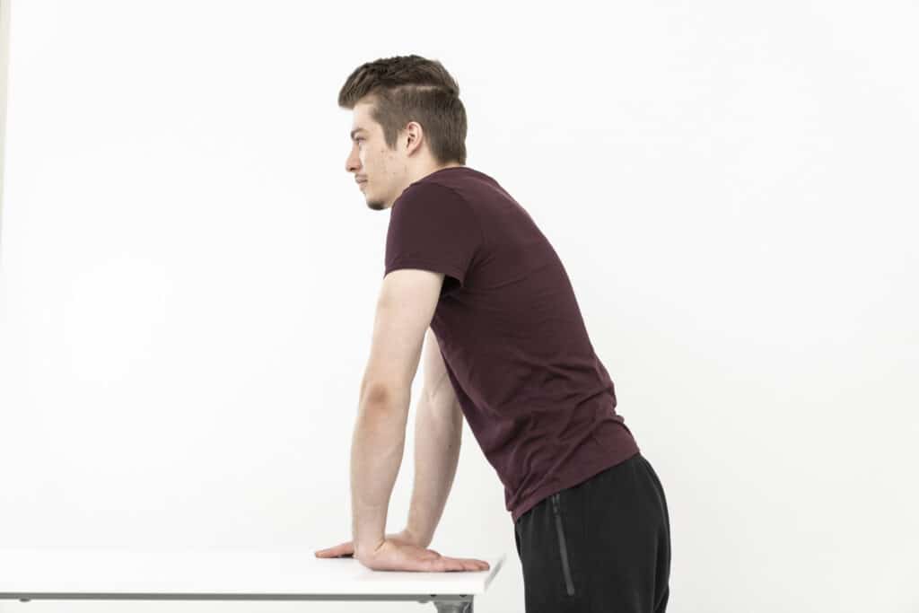 A man is stretching his arm.