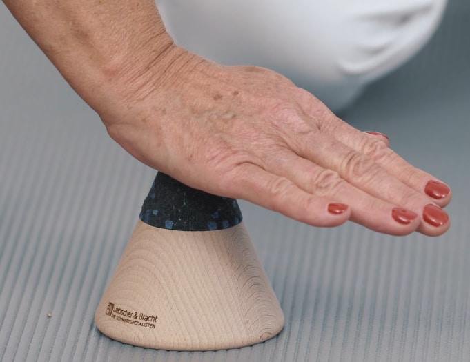 A woman is pressing her hand onto the Osteopressure tool