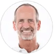 Roland Liebscher-Bracht in a white shirt is kindly smiling.