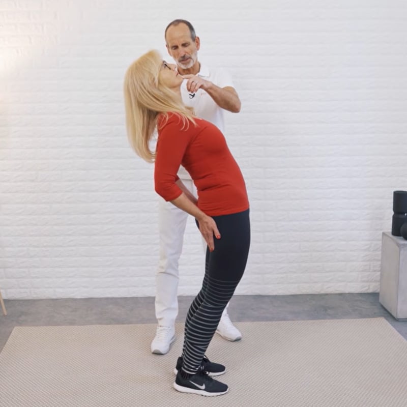 A woman is bending backwards to stretch her back.