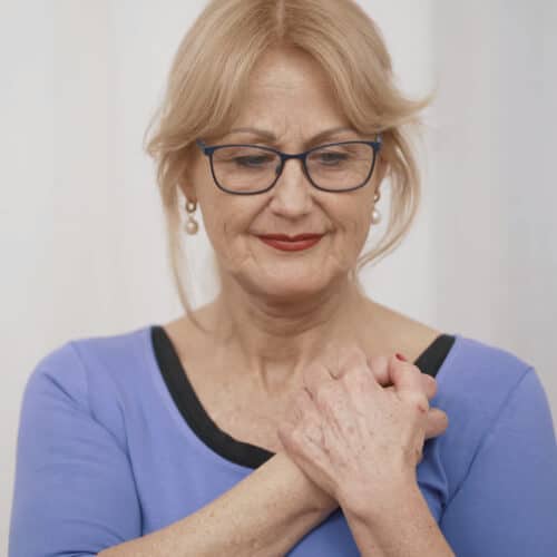 A woman is osteopressing a point near her clavicula.