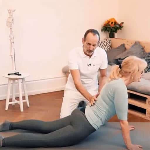 A woman is stretching her back on the floor.