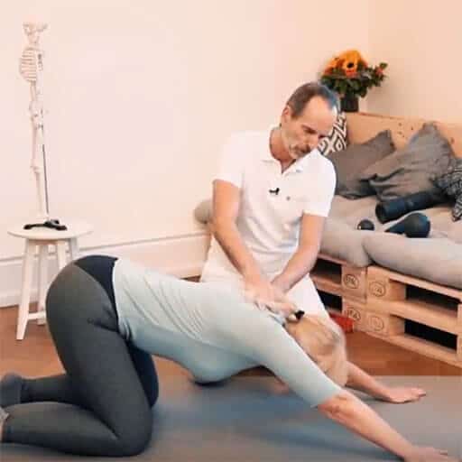 A woman is kneeling on the floor, her arms stretched out to stretch her back.