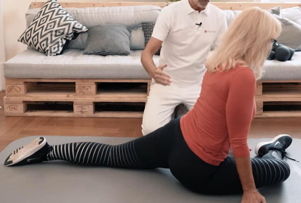 A woman is on the ground, one leg stretched out behind her, the other angled towards her torso.