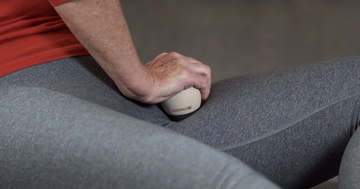 A woman is using an osteopressure tool to relieve her hip pain.