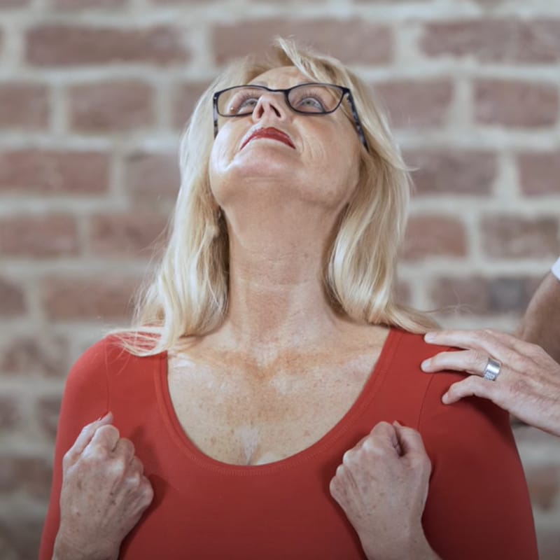 Ina looks towards the ceiling, her neck is straightened. Both hands form fists, the shoulders push downwards.