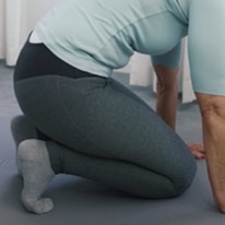 Ina, who is bending her knees on the floor, is stretching the arch of her feet.