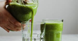 Image of someone pouring green smoothie into a glass; smoothie recipe for osteoarthritis