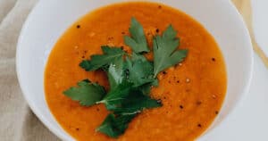 Bowl of soup for osteoarthritis diet; containing carrots, orange - vegan friendly