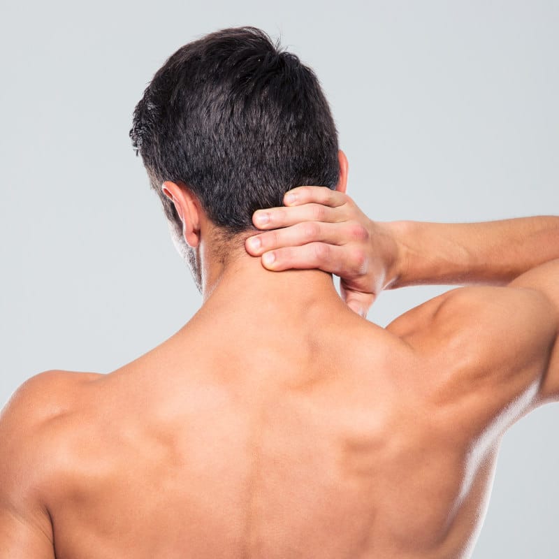 Shot of the back of a man, he's touching his neck.