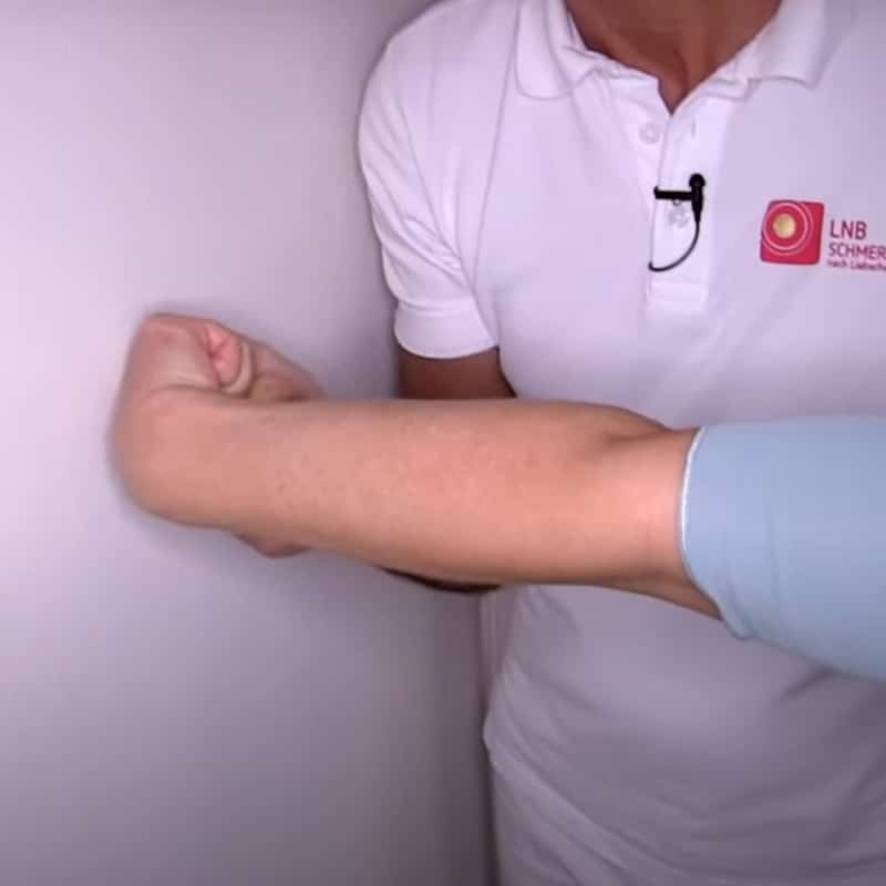 A straightened arm is visible. The hand makes a fist; the wrist is bent and points away from the body.