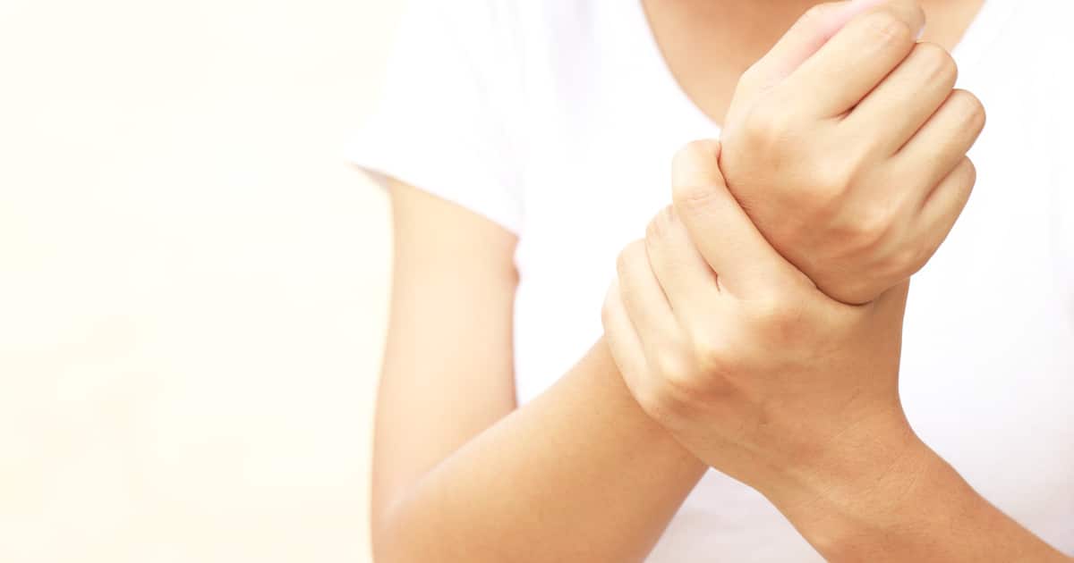 A person clutching their hurting wrists.
