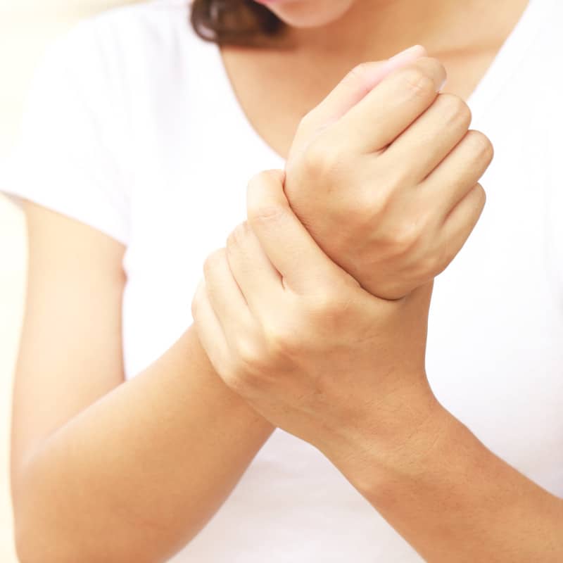 A person clutching their hurting wrists.