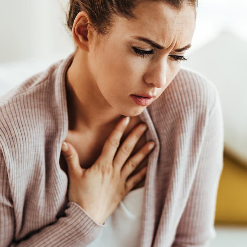 This lady is suffering heartburn.