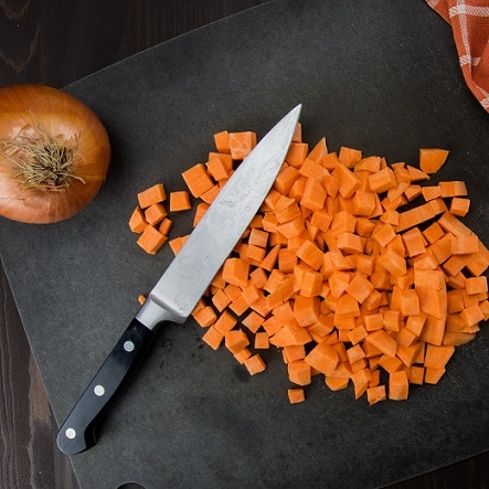 diced sweet potato on chopping board with onion