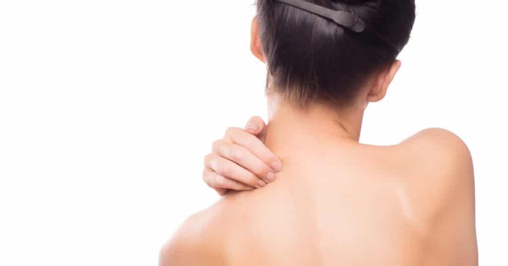 A woman massages her neck to adjust her atlas vertebra.