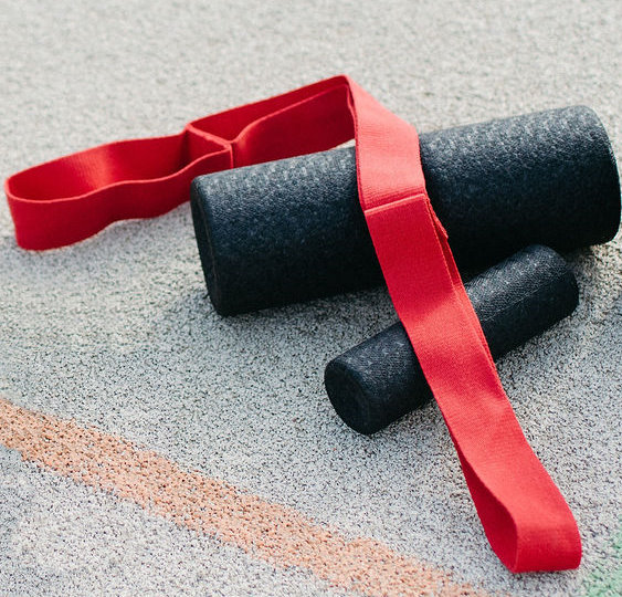 A Stretching Strap and two Foam Rollers on the ground.