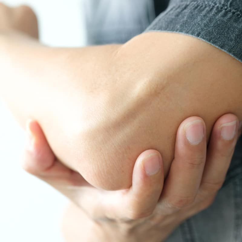 Closeup of a hand on an elbow.