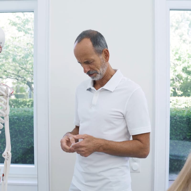 Roland Liebscher-Bracht is standing with a straight back, his neck is tilted forward, his hands and elbows are close to his body, his right and left shoulder are down.