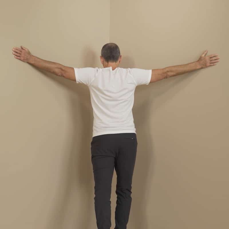 Roland Liebscher-Bracht is standing in the corner of a room with his hands on the wall.