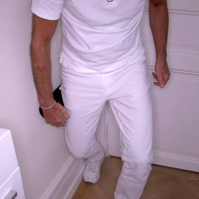 Closeup of Roland Liebscher-Bracht foam rolling his thigh against a wall.