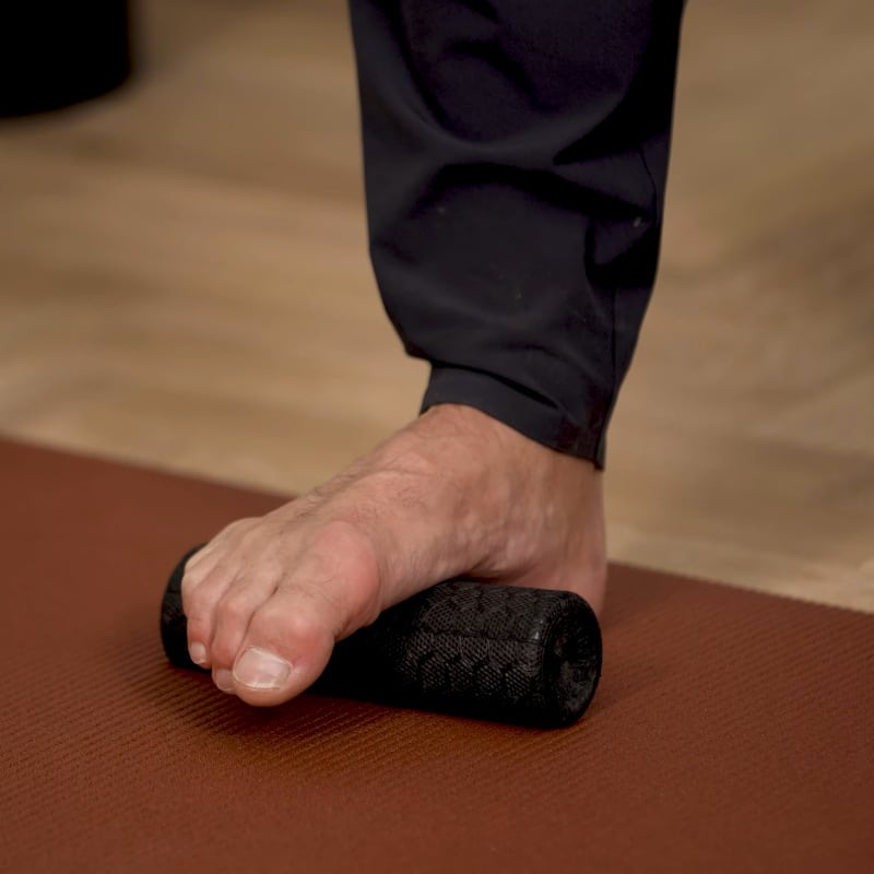 Closeup of Roland Liebscher-Bracht's right foot on the Mini Foam Roller.