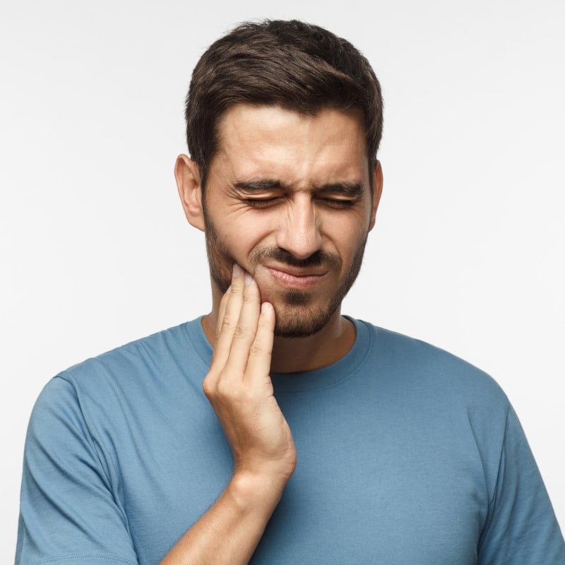 A man is touching his jaw.