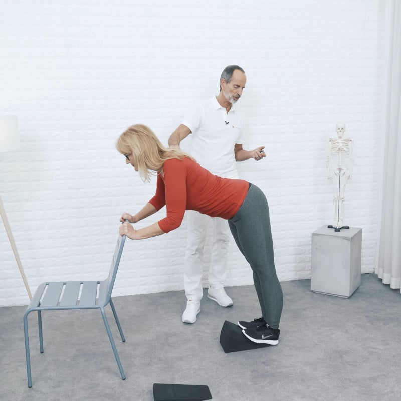 Roland Liebscher-Bracht is demonstrating a stretch for knee pain.