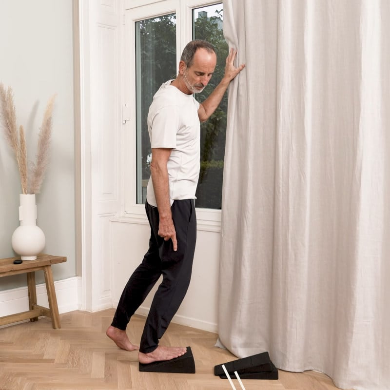 Roland Liebscher-Bracht is stretching his ankle on the Knee Hero.