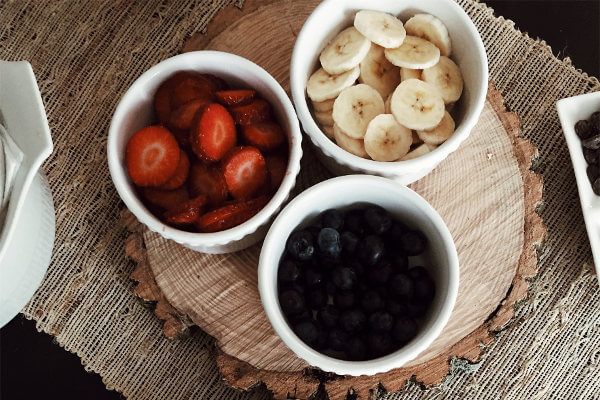 Drei Schlalen mit Erdbeeren, Heidelbeeren und Bananen