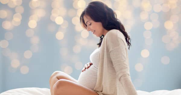 Schwangere Frau hält sich ihren Bauch