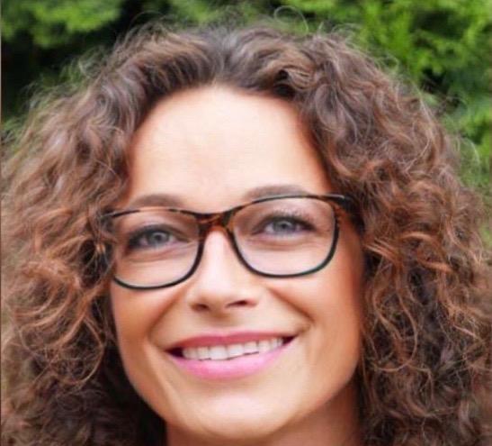 Das Foto zeigt Ines Viehrig aus Wuppertal. Sie hat braune Locken und eine braune eckige Brille. Sie lächert direkt in die Kamera.