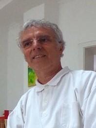 Das Foto zeigt Dr. Philipp Veith, welcher in Jever die Liebscher & Bracht Schmerztherapie praktiziert. Er trägt ein weißes Polo T-Shirt und eine randlose Brille. Er hat kurzes lockiges graues Haar.