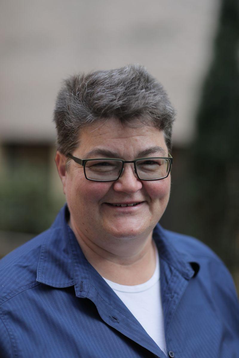 Das Foto zeigt Ilona Hopf auf Postbauer-Heng. Sie hat kurze dunkelgraue Haare und trägt eine eckige schwarze Brille. Auf dem Foto trägt sie ein weißes T-Shirt und eine dunkelblaue Bluse.