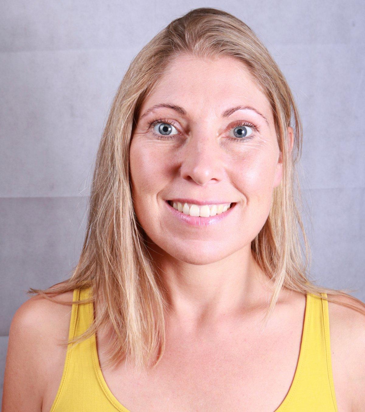 Auf dem Foto lacht Irene Bohmann aus Würzburg in die Kamera. Sie hat lange blonde Haare und trägt ein gelbes Top.