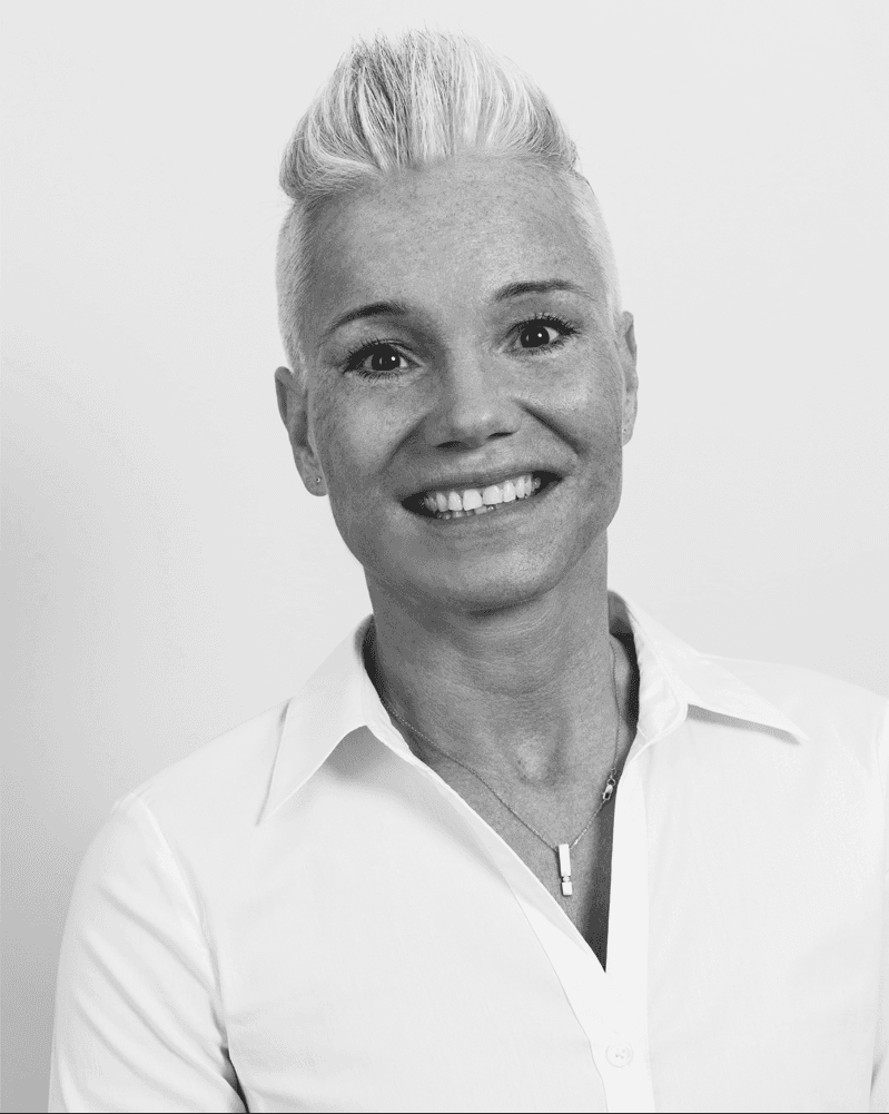 Das schwarz-weiße Portraitfoto von Cathrin Theissen aus Dittelbrunn zeigt Physiotherapeutin Cathrin Theissen sympathisch lächelnd. Sie hat kurze helle Haare und trägt eine helle Bluse.