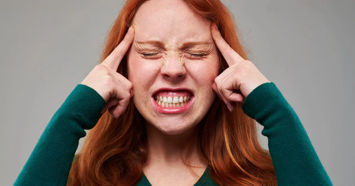 Frau beißt die Zähne aufeinander