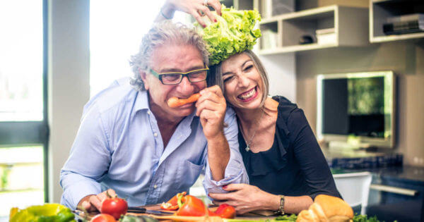Älteres Ehepaar scherzt mit Gemüse in der Küche