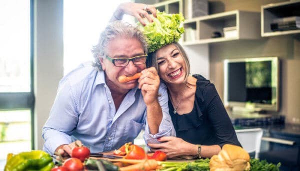 Älteres Ehepaar scherzt mit Gemüse in der Küche