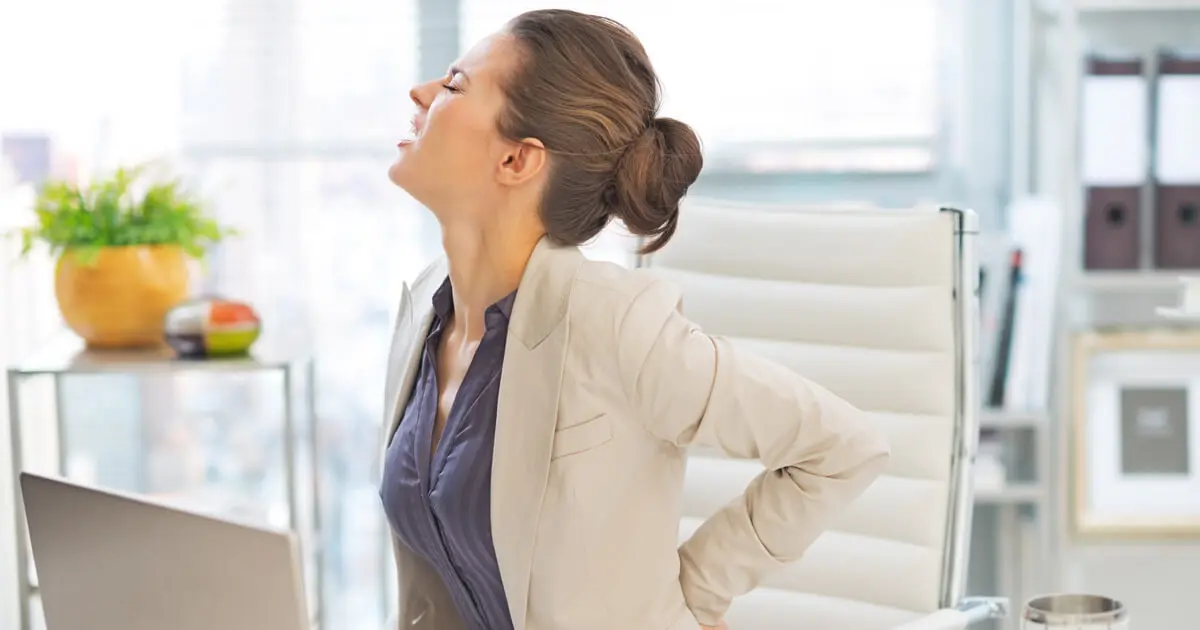 Eine Frau hat Rückenschmerzen im Büro