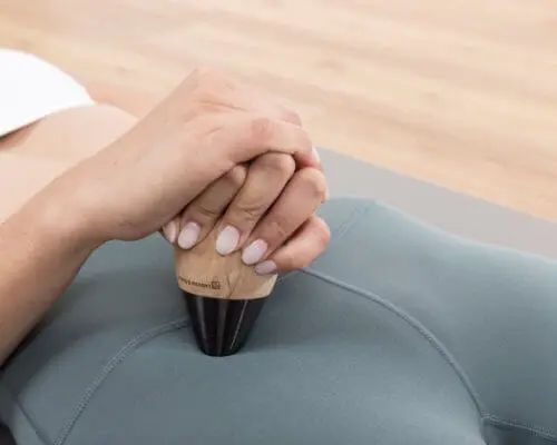 Anwendung des Schmerzfrei-Drückers mit kugelförmigem Griffstück. Die Patientin drückt einen Knochenpunkt am Schambein