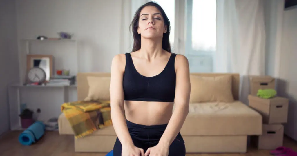 Frau atmet bewusst in den Bauch und sieht entspannt aus