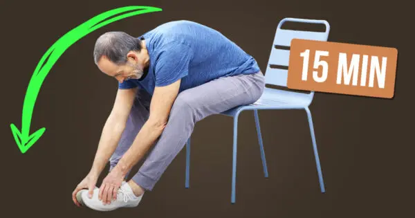 Ein Mann sitzt auf einem Stuhl und beugt sich nach vorne zu seinen Zehen.