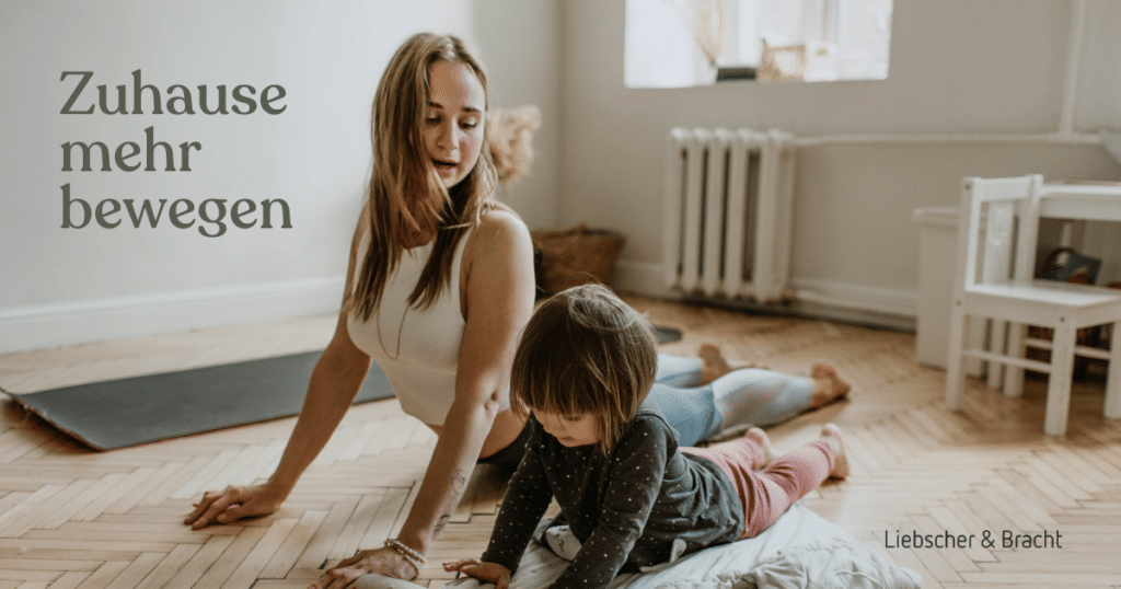 Eine Frau und ein Mädchen machen nebeneinander auf dem Fußboden Yoga.