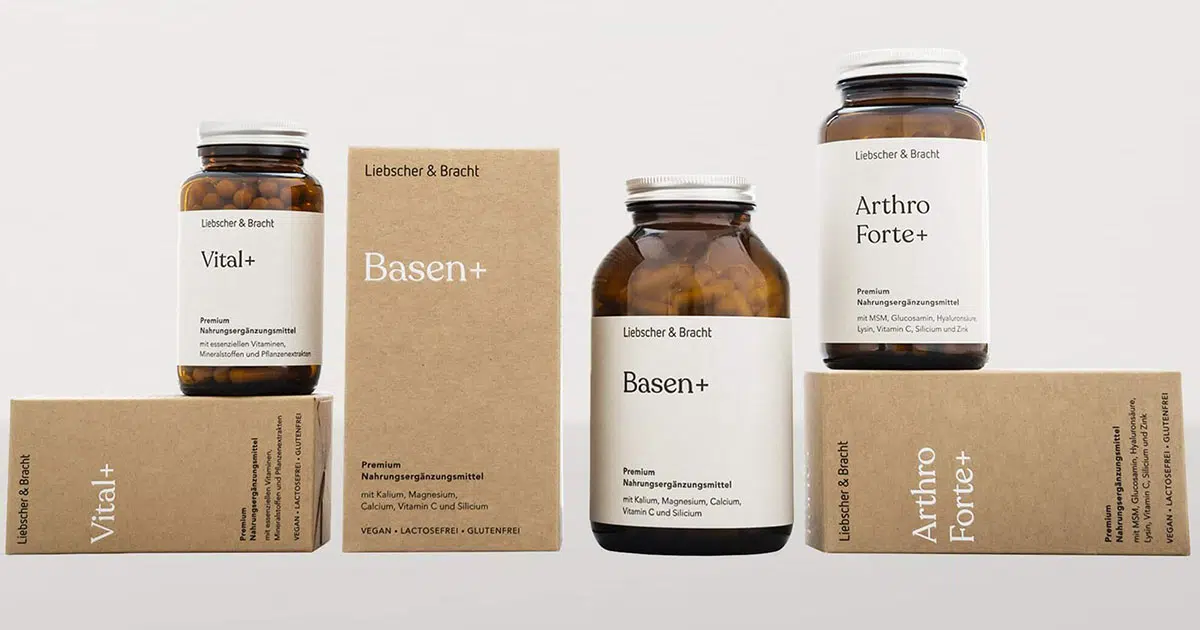 Abgebildet sind drei Nahrungsergänzungsmittel in Braunglasflaschen. Die linke Flasche steht auf der umweltfreundlichen Verpackung, die mittlere steht neben ihrer umweltfreundlichen Verpackung, die rechte steht auf ihrer umweltfreundlichen Verpackung